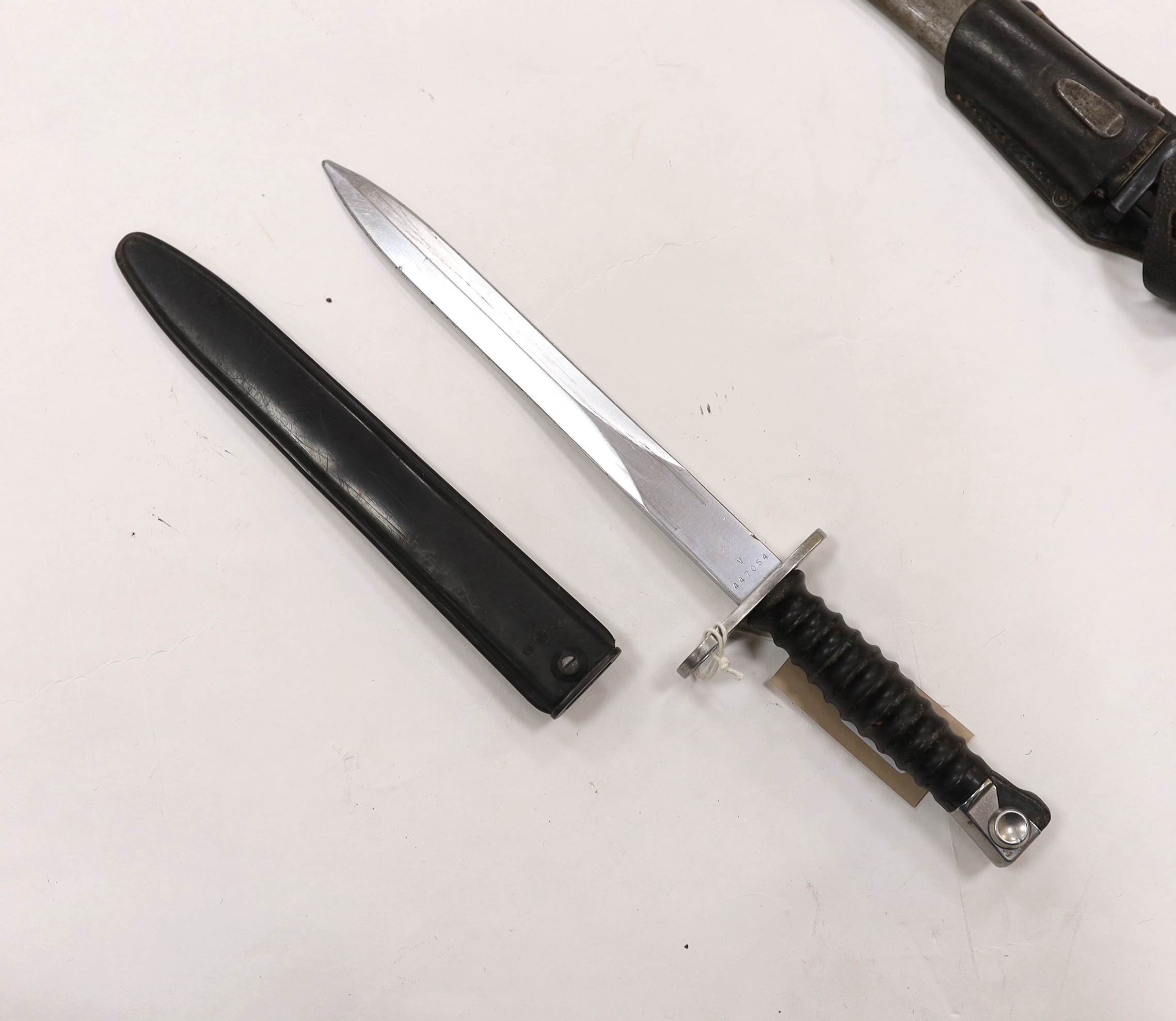 Four bayonets; two Mauser bayonets in scabbards, an American M8A1 carbine bayonet in a scabbard, and another